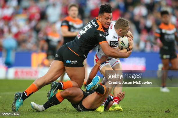 Matt Duffy of the Dragons is tackled by Sauaso Sue of the Tigers during the round 18 NRL match between the St George Illawarra Dragons and the Wests...