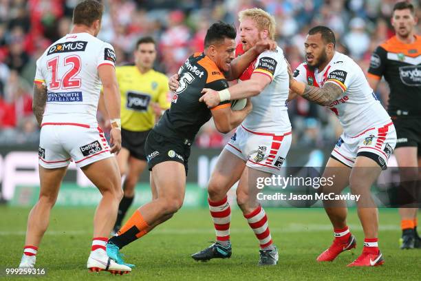 Sauaso Sue of the Tigers is tackled by James Graham of the Dragons during the round 18 NRL match between the St George Illawarra Dragons and the...