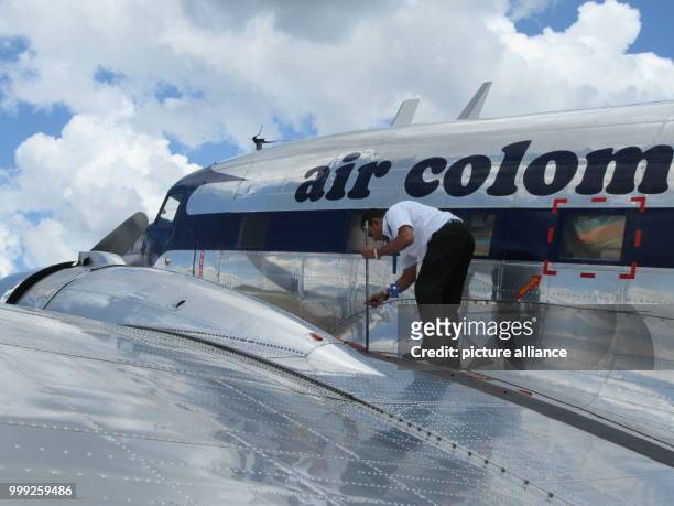 Pilot of an Air Columbia Douglas DC-3 checks the fuel at the Vanguardia Airport in Villavicencio, Colombia, 16 March 2017. Photo: Bernd Kubisch/dpa
