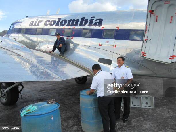 Pilots of an Air Columbia Douglas DC-3 check the fuel at Vanguardia Airport in Villavicencio, Colombia, 16 March 2017. Photo: Bernd Kubisch/dpa