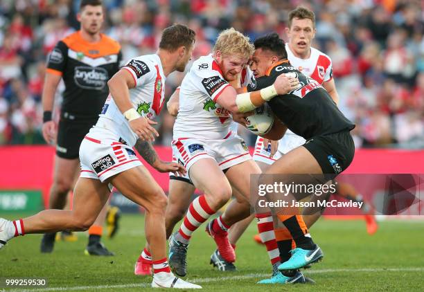 Elijah Taylor of the Tigers is tackled by James Graham of the Dragons during the round 18 NRL match between the St George Illawarra Dragons and the...