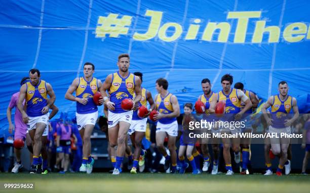 The Eagles run through their banner during the 2018 AFL round 17 match between the Collingwood Magpies and the West Coast Eagles at the Melbourne...