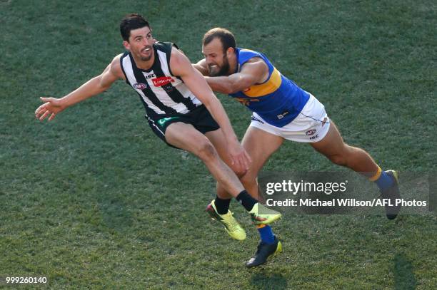 Scott Pendlebury of the Magpies is tackled by Will Schofield of the Eagles during the 2018 AFL round 17 match between the Collingwood Magpies and the...