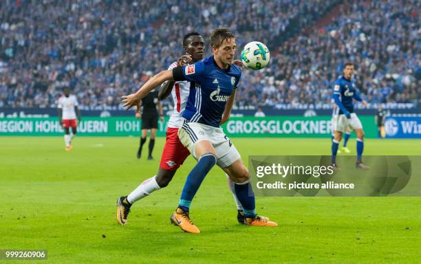 Schalke's Bastian Oczipka nd Leipzig's Bruma vie for the ball during the German Bundesliga football match between FC Schalke 04 and RB Leipzig at the...