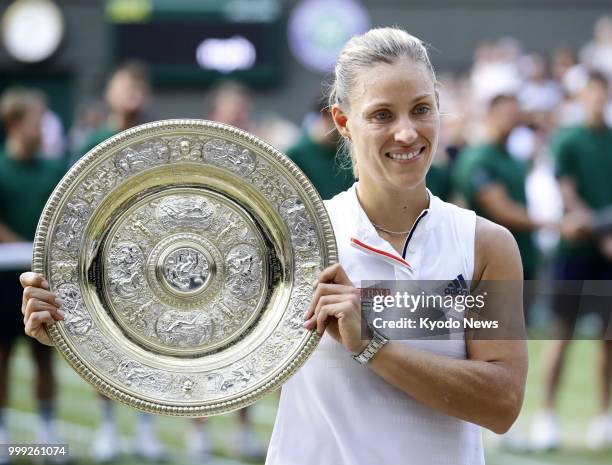 Angelique Kerber of Germany poses with the winner's trophy after her victory over Selena Williams of the United States in the women's singles final...