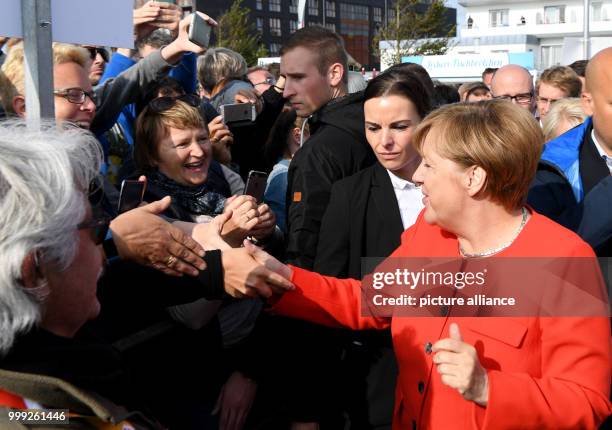 German Chancellor Angela Merkel is greeted by citizens as she arrives at a CDU election campaign event in St.Peter-Ording, Germany, 21 August 2017....