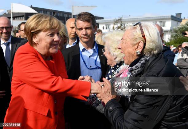 German Chancellor Angela Merkel is greeted by citizens as she arrives at a CDU election campaign event in St.Peter-Ording, Germany, 21 August 2017....