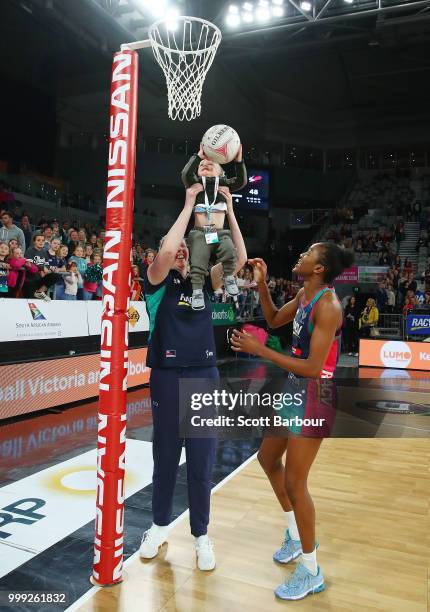 Emma Ryde of the Vixens holds Jacob Ingles up so he can shoot the ball as Kadie-Ann Dehaney looks on after the round 11 Super Netball match between...