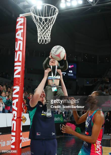 Emma Ryde of the Vixens holds Jacob Ingles up so he can shoot the ball as Kadie-Ann Dehaney looks on after the round 11 Super Netball match between...
