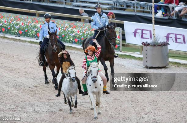 Rider dressed as Pippi Longstocking followed by fictive police officers in the Ullevi Stadion at the official opening of the Longines FEI European...