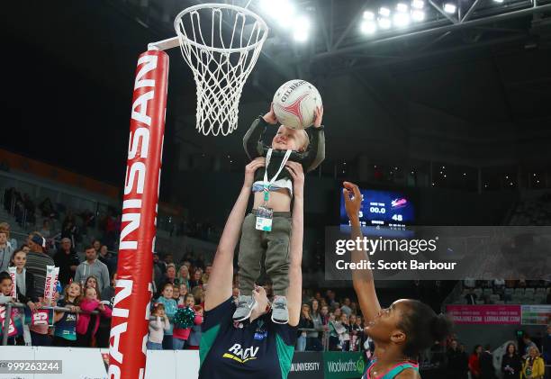 Emma Ryde of the Vixens holds Jacob Ingles up so he can shoot the ball as Kadie-Ann Dehaney looks on after the round 11 Super Netball match between...