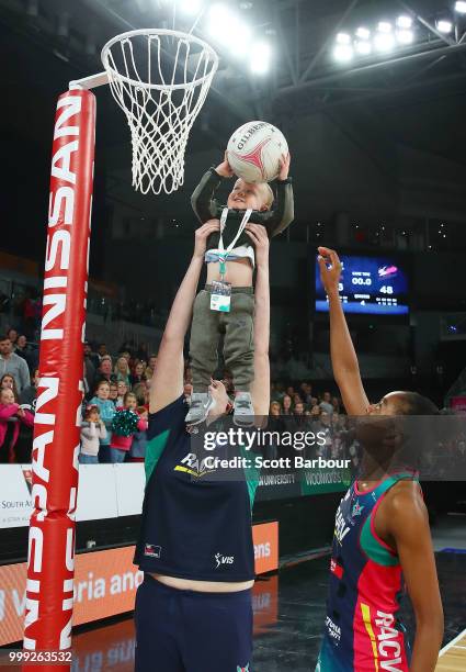 Emma Ryde of the Vixens holds Jacob Ingles up so he can shoot the ball as Kadie-Ann Dehaney looks on after the round 11 Super Netball match between...