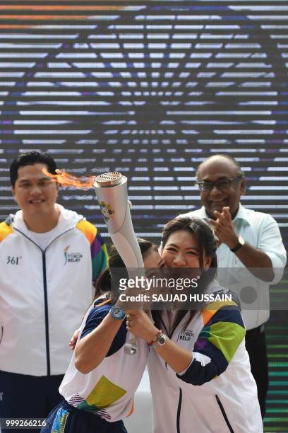 Indian boxer Mary Kom and former badminton player Susi Susanti , the torch ambassador from Indonesia, hug each other as they take part in the start...