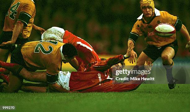 Jamie Robinson of Wales gets the ball away after being tackled by Graeme Bond of Australia during the match between Wales and Australia at the...