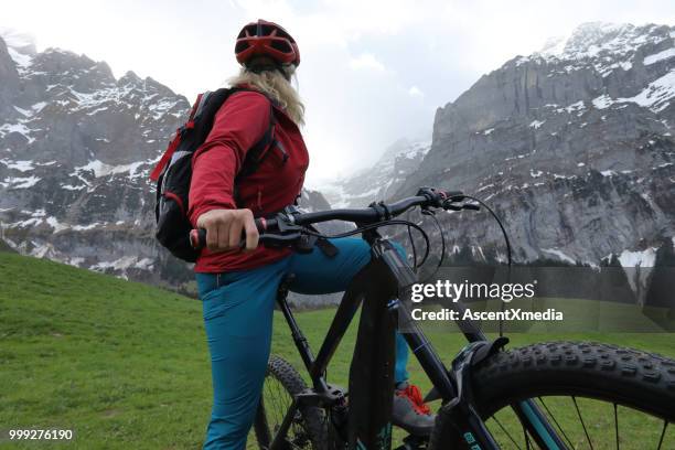 frau reitet e-bike in den schweizer alpen - eskapismus stock-fotos und bilder