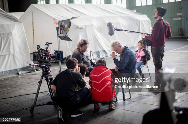 The Chinese artist Ai Weiwei speaks with his film team at a hangar of the refugee emergency shelter at the former Tempelhof Airport in Berlin,...