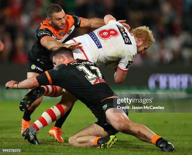 James Graham of the Dragons is tackled by Robbie Farah and Matt Eisenhuth of the Tigers during the round 18 NRL match between the St George Illawarra...