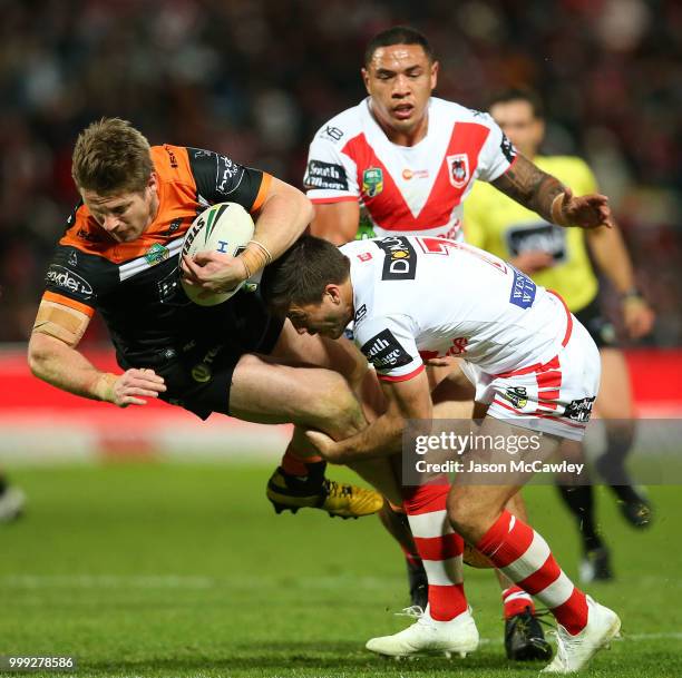 Chris Lawrence of the Tigers is tackled by Ben Hunt of the Dragons during the round 18 NRL match between the St George Illawarra Dragons and the...