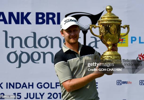 Justin Harding of South Africa poses with his trophy after winning the Indonesia Open golf tournament at the Pondok Indah Golf Course in Jakarta on...