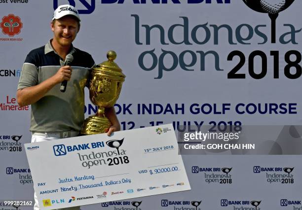 Justin Harding of South Africa poses with his trophy and a mock cheque after winning the Indonesia Open golf tournament at the Pondok Indah Golf...