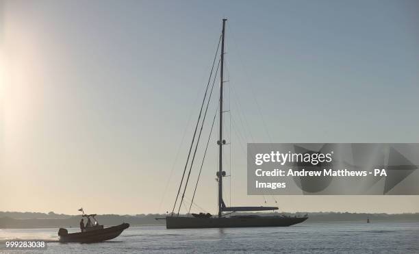 Makes it's way past a moored sailing boat in Southampton Water as the sun rises