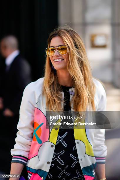 Lorena Vergani wears a colored bomber jacket, a black top with printed white cross, outside Dior, during Paris Fashion Week - Menswear Spring-Summer...