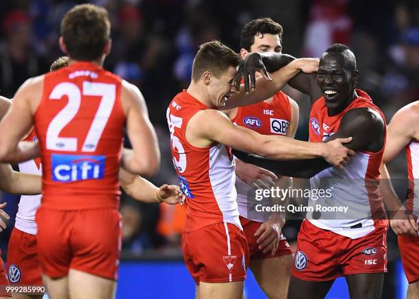 Aliir Aliir of the Swans is congratulated by team mates after kicking the winning goal during the round 17 AFL match between the North Melbourne...