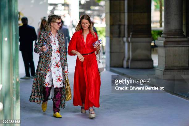 Guest wears a printed geometric pattern coat, a long flower print shirt, purple pants, yellow shoes ; a guest wears a red dress, outside Dior, during...