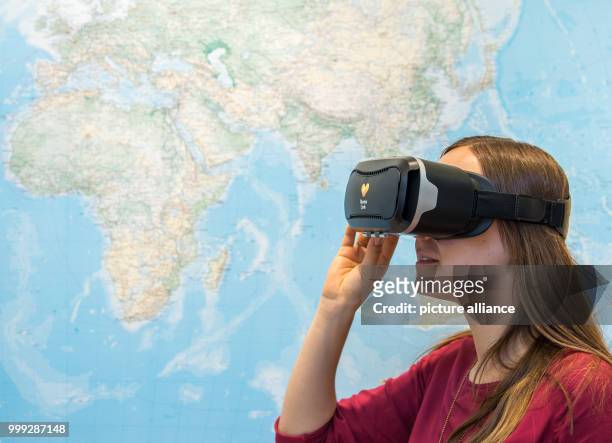 Picture of a woman looking at potential travel destinations through virtual reality headsets in a travel agency in Hanover, Germany, 16 August 2017....
