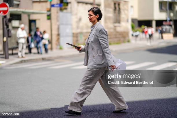 Anastasia Barbieri wears a gray blazer jacket, flared pants, outside Wooyoungmi, during Paris Fashion Week - Menswear Spring-Summer 2019, on June 23,...