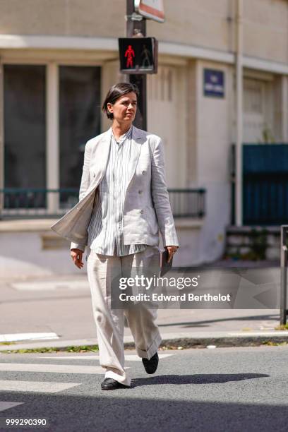 Anastasia Barbieri wears a gray blazer jacket, flared pants, outside Wooyoungmi, during Paris Fashion Week - Menswear Spring-Summer 2019, on June 23,...