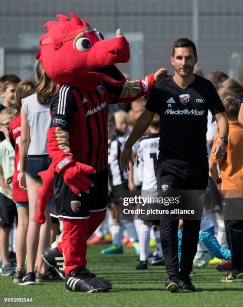 The new Ingolstadt coach Stefan Leitl is greeted by mascot Schanzi at a training session of German 2nd Bundesliga football club FC Ingolstadt 04 at...