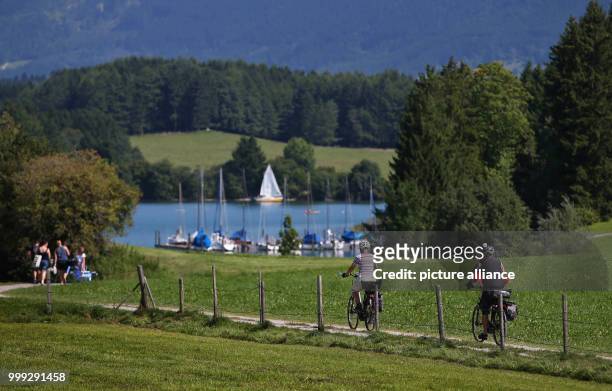 People on their way to Forggensee lake near Dietringen, Germany, 23 August 2017. Photo: Karl-Josef Hildenbrand/dpa