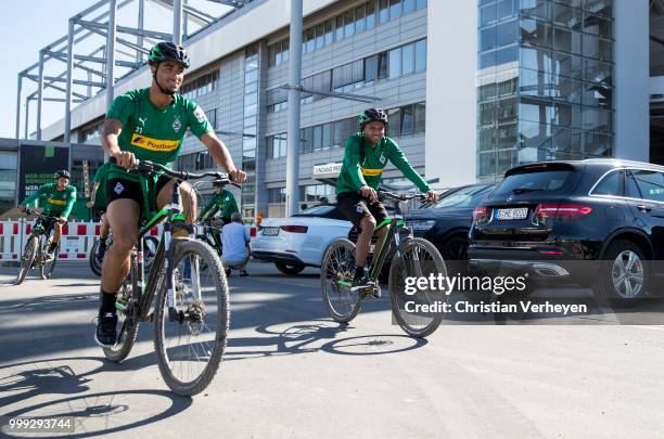 Keanan Bennetts and Raffael go by bike during a training session of Borussia Moenchengladbach at Borussia-Park on July 15, 2018 in Moenchengladbach,...