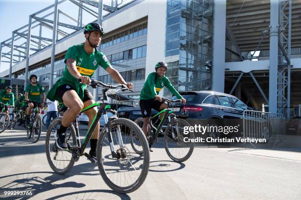 Keanan Bennetts and Raffael go by bike during a training session of Borussia Moenchengladbach at Borussia-Park on July 15, 2018 in Moenchengladbach,...