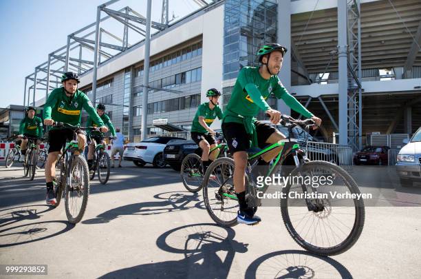 Fabian Johnson and Jonas Hofmann go by bike during a training session of Borussia Moenchengladbach at Borussia-Park on July 15, 2018 in...