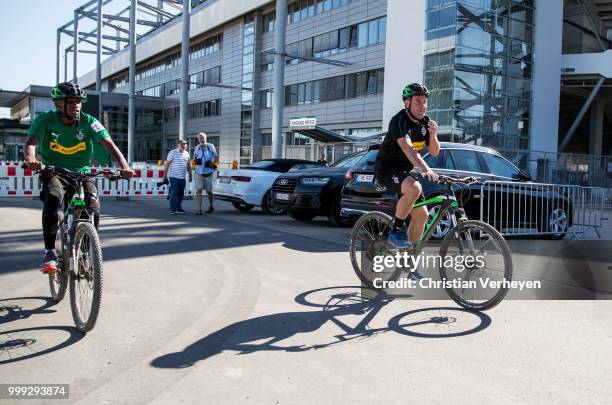 Headcoach Dieter Hecking and Ibrahima Traore go by bike during a training session of Borussia Moenchengladbach at Borussia-Park on July 15, 2018 in...