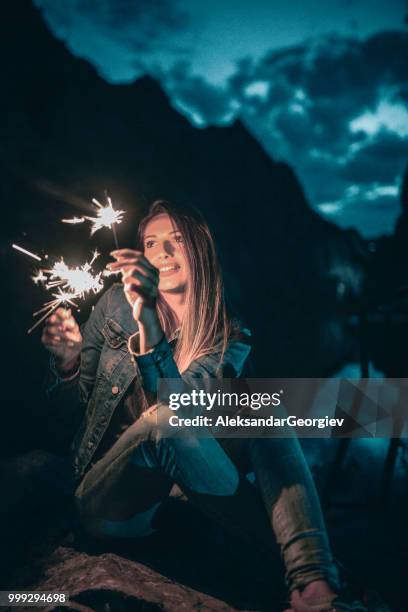 linda mujer jugando con bujías durante fiesta de lago de montaña - aleksandar georgiev fotografías e imágenes de stock