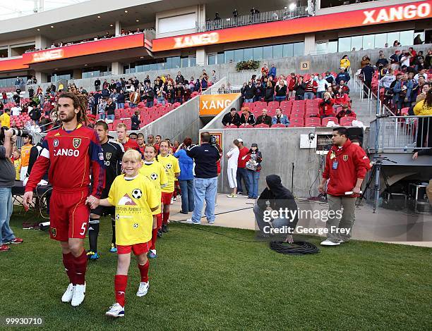 Kyle Beckerman of Real Salt Lake leads a child onto the field before the start of the MLS soccer game against the Houston Dynamo on May 13, 2010 in...