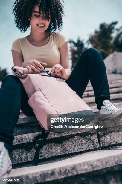 linda estudiante cierre la cremallera de la mochila mientras se relaja en las escaleras - aleksandar georgiev fotografías e imágenes de stock