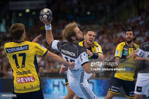 Kiel's Steffen Weinhold in a duel against Rhein-Neckar Loewen's Jerry Tollbring and Hendrik Pekeler during the DHB-Supercup handball match between...