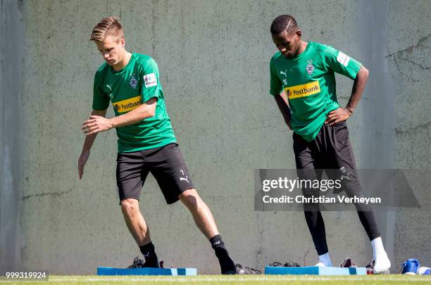 Patrick Herrmann and Ibrahima Traore stretch during a training session of Borussia Moenchengladbach at Borussia-Park on July 15, 2018 in...