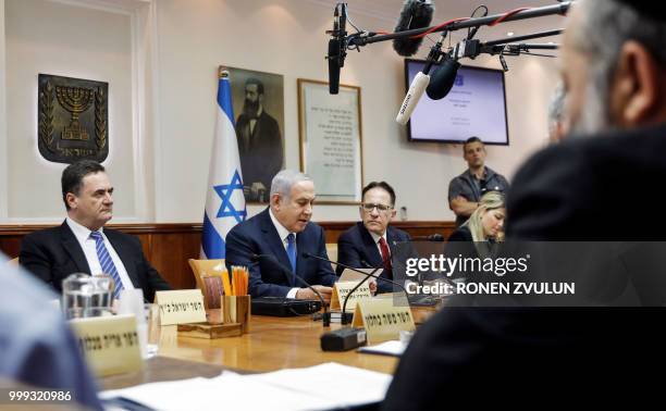 Israeli Prime Minister Benjamin Netanyahu attends with his ministers the weekly cabinet meeting at his office in Jerusalem on July 15 accompanied by...