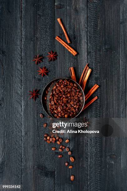 coffee beans in the metal plates and spices on the black wooden - alina stockfoto's en -beelden