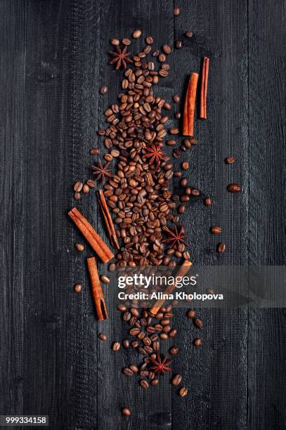 coffee beans and spices on the black wooden table - alina stockfoto's en -beelden