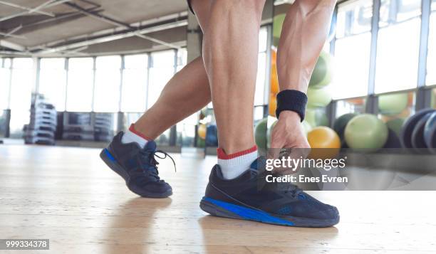 fitness instructor tying his shoelace - lacing trainers stock pictures, royalty-free photos & images
