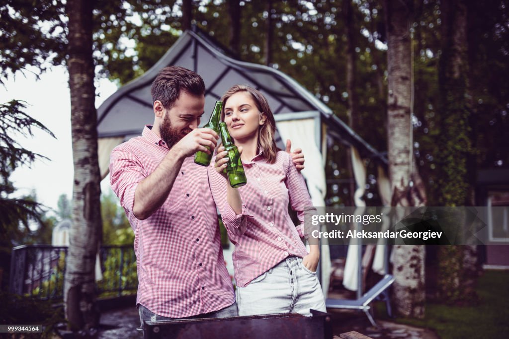 Cute Young Couple Drinking Beer After A Good Barbecue Dinner