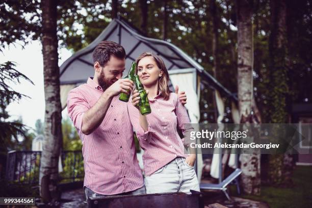 cute young couple drinking beer after a good barbecue dinner - park man made space stock pictures, royalty-free photos & images