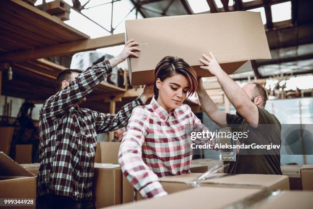 team of factory workers taping and preparing boxes for shipment - change dispenser stock pictures, royalty-free photos & images