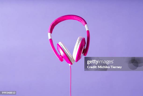 pink headphones on a purple background - animal hand stock pictures, royalty-free photos & images